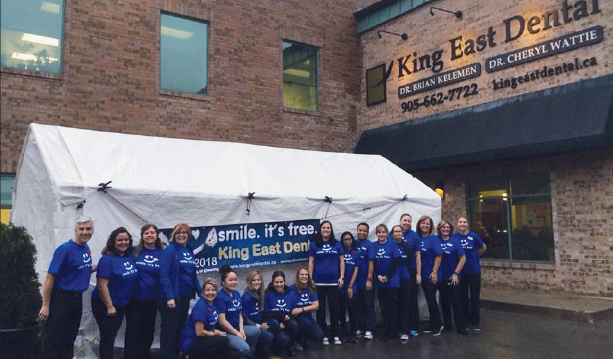 The team of volunteers at Dentistry from the Heart event standing in front of the King East Dental building