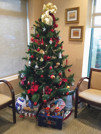 Christmas tree with donated food items placed under it