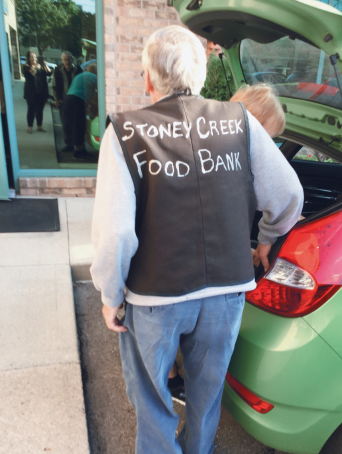 Man standing beside trunk of car from Stoney Creek Food Bank