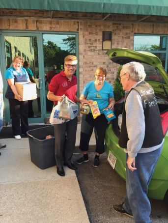 King East Dental team members loading donated food items into back of car